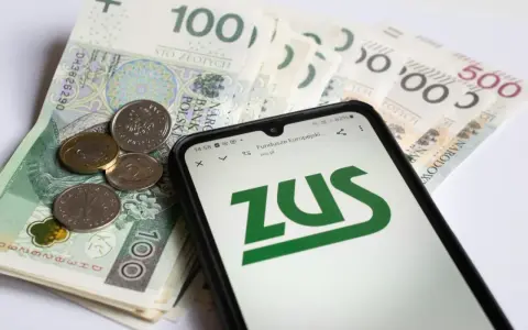 Złotówki i monety obok telefonu z logo ZUS. Może to być związane z wnioskiem o zasiłek opiekuńczy.