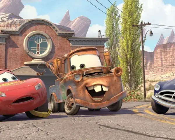 Zabawne auta z bajki: Zygzak McQueen, Złomek i Doc Hudson na tle Route 66.