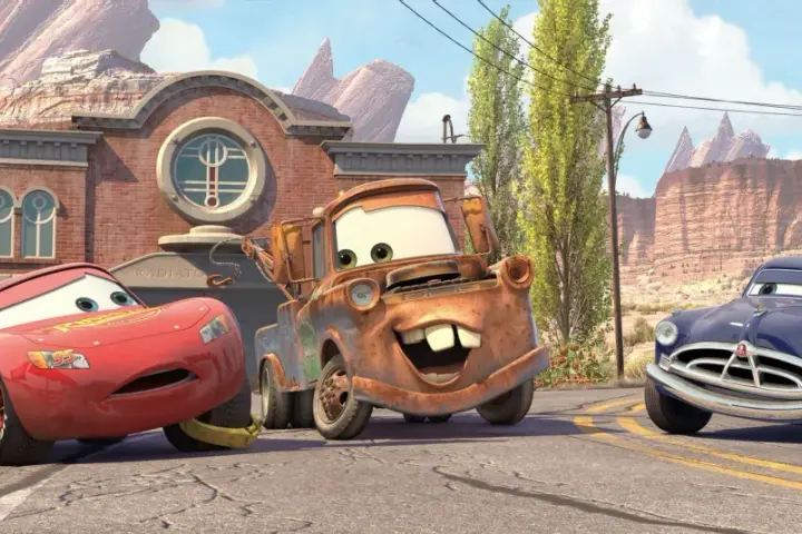 Zabawne auta z bajki: Zygzak McQueen, Złomek i Doc Hudson na tle Route 66.